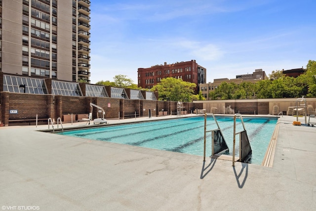 community pool with fence and a patio