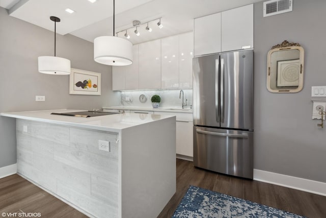 kitchen featuring a sink, visible vents, white cabinetry, freestanding refrigerator, and dark wood finished floors