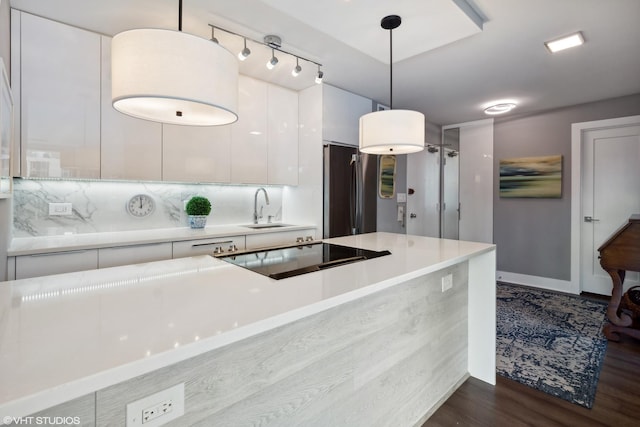 kitchen featuring dark wood finished floors, freestanding refrigerator, white cabinetry, a sink, and modern cabinets