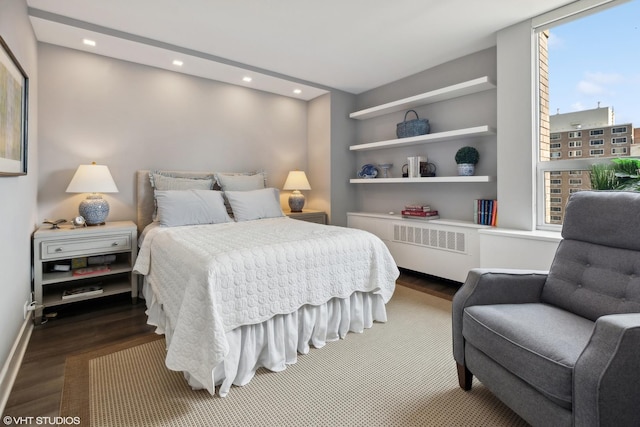 bedroom featuring radiator heating unit, baseboards, wood finished floors, and recessed lighting