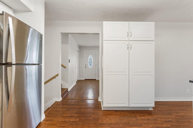 kitchen with dark wood-style floors, freestanding refrigerator, white cabinetry, a textured ceiling, and baseboards