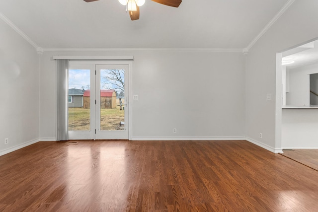 empty room with crown molding, baseboards, ceiling fan, and wood finished floors