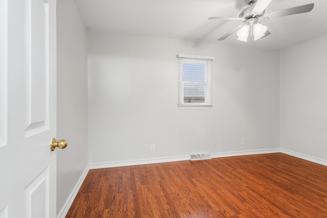 unfurnished room with a ceiling fan, wood finished floors, visible vents, and baseboards