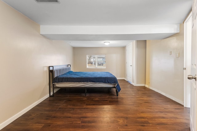 bedroom featuring wood finished floors, visible vents, and baseboards