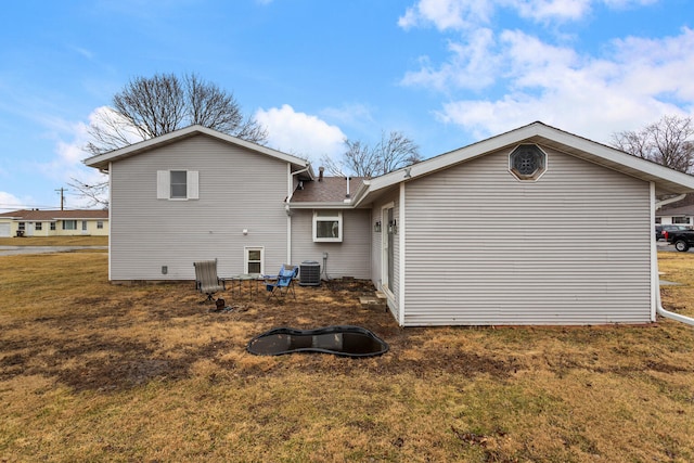 rear view of house featuring a lawn and central air condition unit