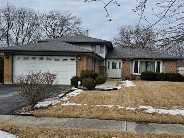 view of front facade featuring a garage, driveway, brick siding, and roof with shingles