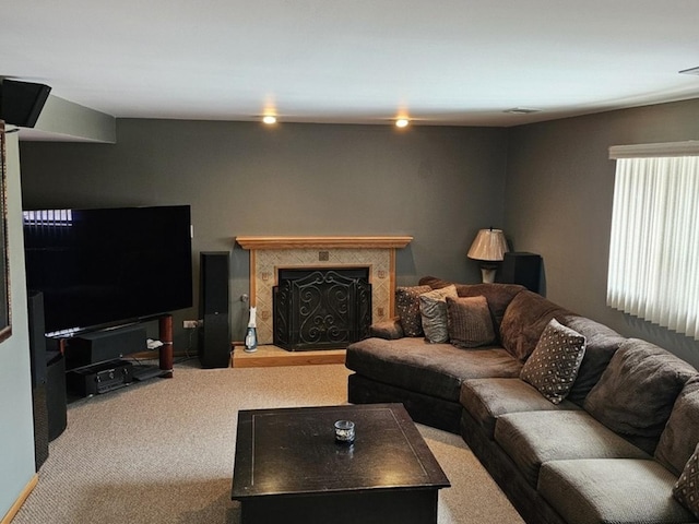 carpeted living area with a fireplace with raised hearth