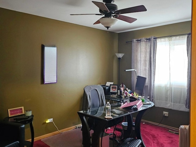 carpeted office with ceiling fan and baseboards