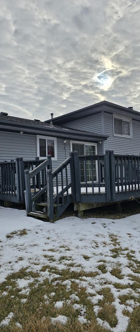 snow covered house featuring a wooden deck