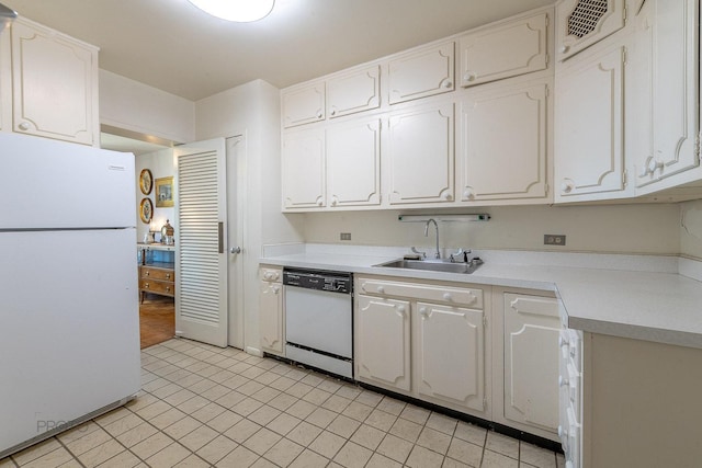 kitchen featuring white cabinets, white appliances, light countertops, and a sink