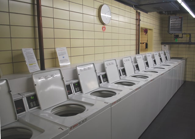 community laundry room with washer and clothes dryer and tile walls