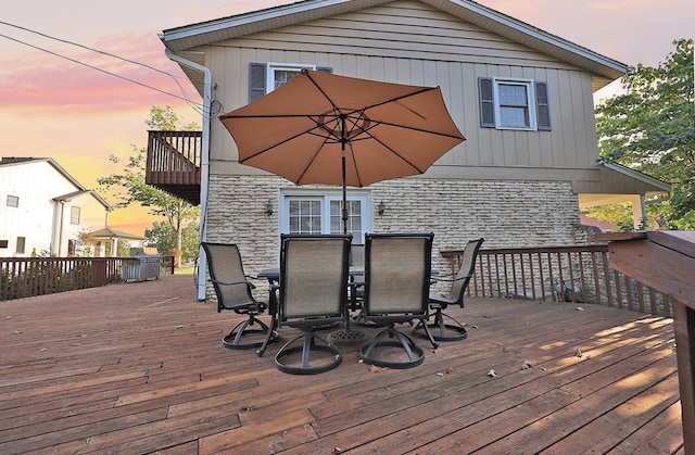 deck at dusk with outdoor dining space