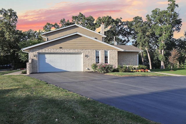 view of front of home featuring a garage, concrete driveway, brick siding, and a yard