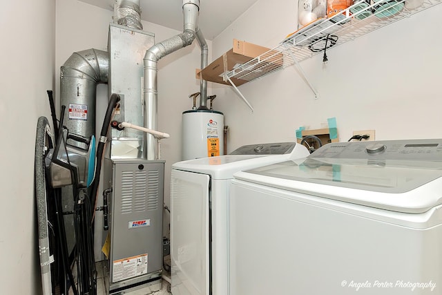 laundry area with laundry area, washing machine and dryer, and water heater