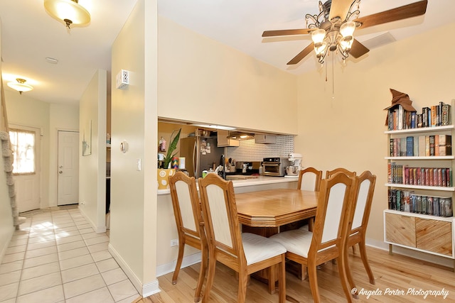 dining space with light tile patterned floors, a toaster, baseboards, and ceiling fan