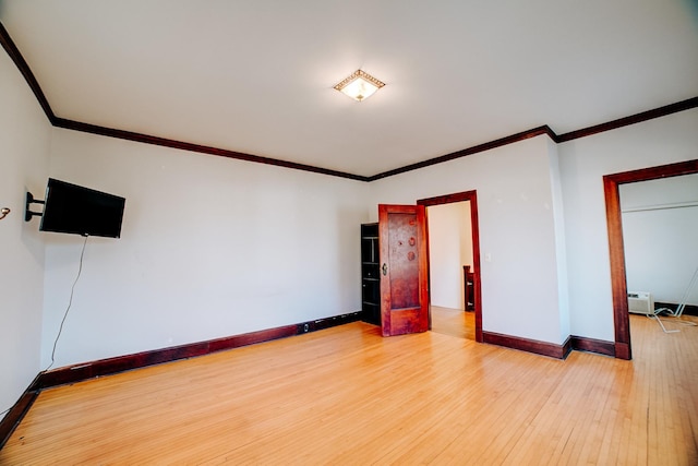 unfurnished room with baseboards, crown molding, and light wood finished floors