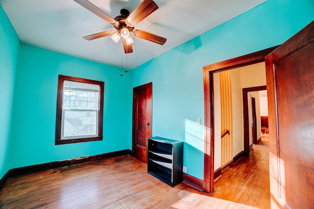 spare room featuring a ceiling fan, baseboards, and wood finished floors