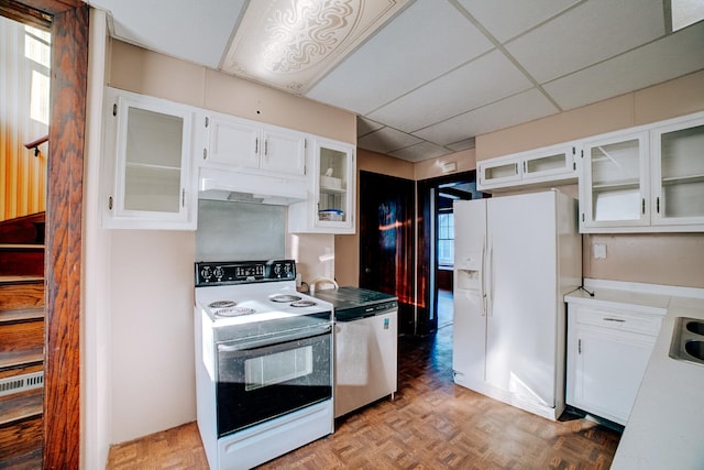 kitchen featuring light countertops, glass insert cabinets, white cabinets, white appliances, and under cabinet range hood