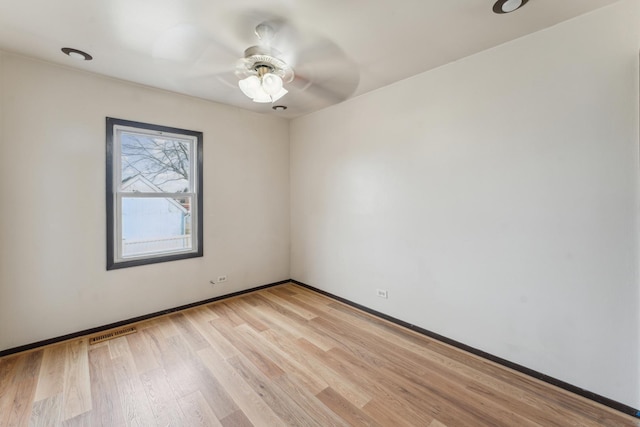 empty room with light wood-style flooring, visible vents, ceiling fan, and baseboards