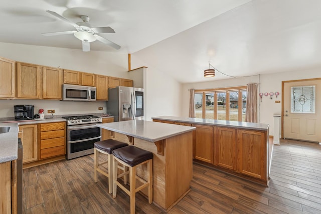 kitchen with vaulted ceiling, appliances with stainless steel finishes, dark wood-type flooring, and a center island