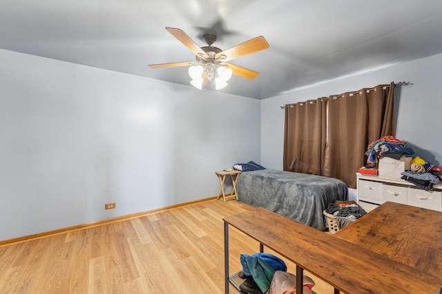 bedroom with light wood finished floors, ceiling fan, and baseboards