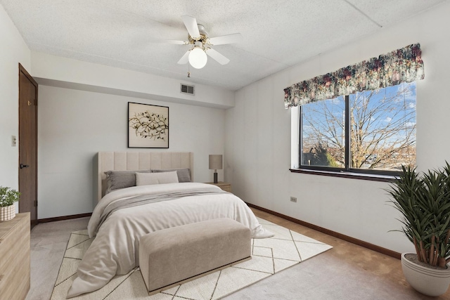 bedroom with visible vents, baseboards, light colored carpet, and a textured ceiling