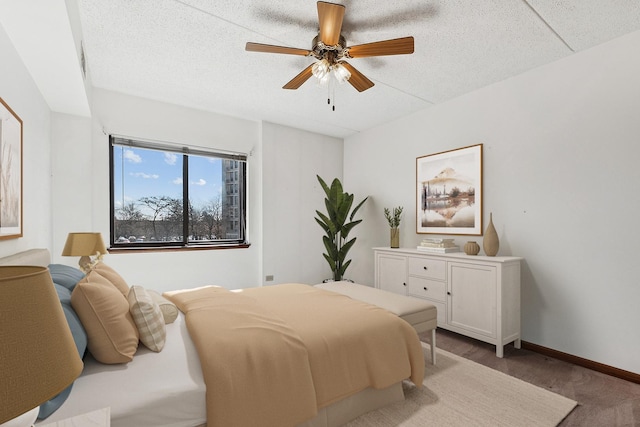 bedroom with baseboards, a textured ceiling, and a ceiling fan