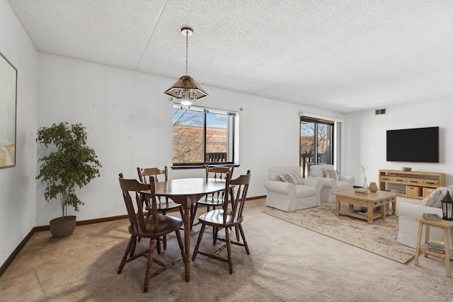 dining space with visible vents, baseboards, carpet floors, and a textured ceiling