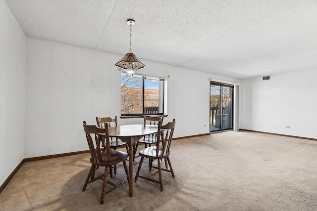 carpeted dining space featuring visible vents, baseboards, and a textured ceiling