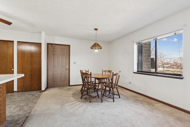 dining room featuring baseboards, carpet floors, and a textured ceiling