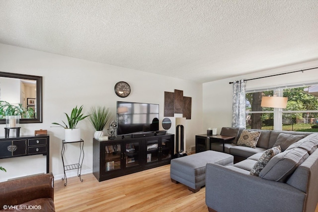 living area featuring light wood-type flooring and a textured ceiling