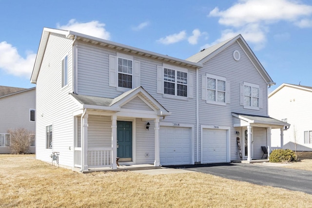 view of property featuring driveway, covered porch, an attached garage, and a front yard