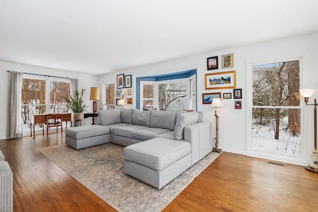 living area with visible vents, baseboards, and wood finished floors