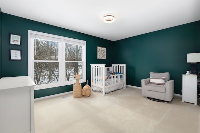 carpeted bedroom with visible vents, baseboards, and a nursery area