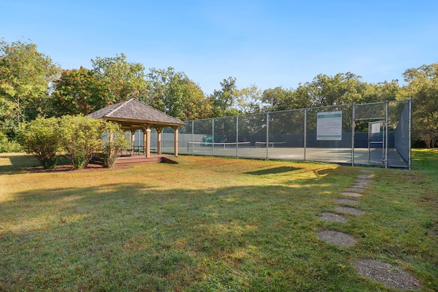 exterior space featuring a gazebo, fence, and a lawn