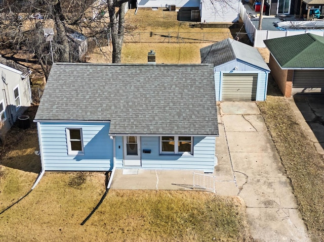 view of front of house featuring a garage, central AC, a shingled roof, an outdoor structure, and concrete driveway