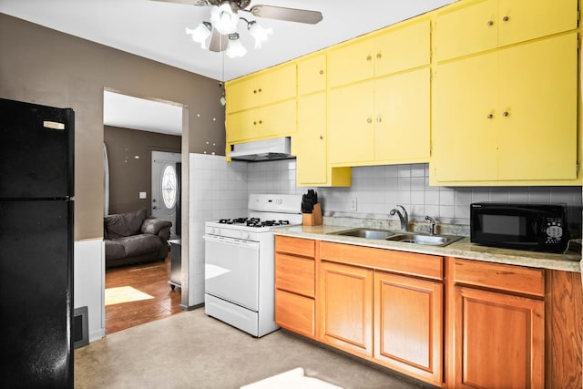 kitchen featuring under cabinet range hood, a sink, light countertops, backsplash, and black appliances