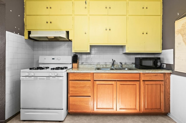 kitchen with white gas range oven, light countertops, under cabinet range hood, black microwave, and a sink