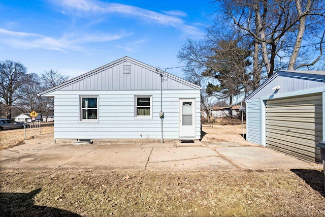 back of house featuring an outbuilding, driveway, and a detached garage