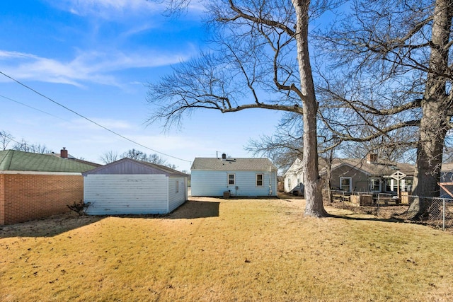 rear view of house featuring an outbuilding, a shed, and fence