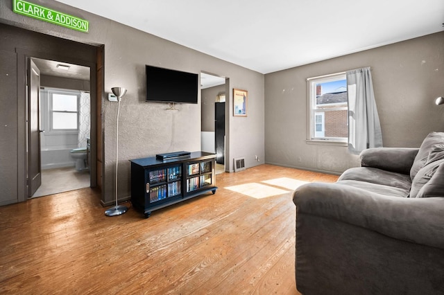 living area featuring light wood-style floors and visible vents