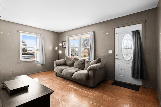 living room with light wood-type flooring and a textured wall