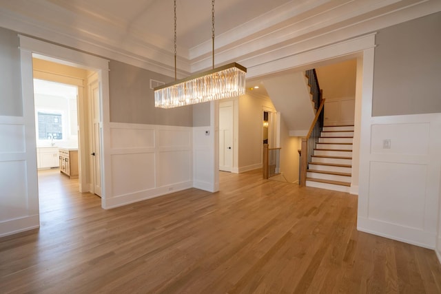 591 S Saylor Ave, Elmhurst, IL 60126 - unfurnished dining area featuring wood finished floors, a decorative wall, a chandelier, and stairway