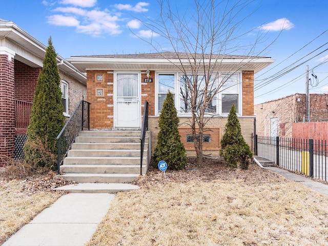 bungalow-style home featuring fence and brick siding