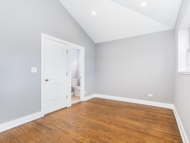 unfurnished room featuring vaulted ceiling, recessed lighting, wood finished floors, and baseboards