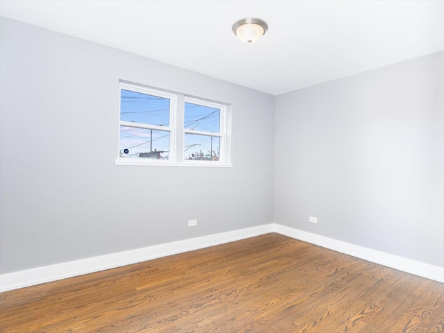 spare room with wood finished floors and baseboards