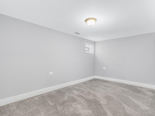 carpeted spare room featuring baseboards