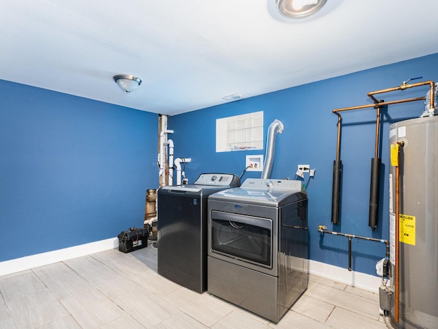 laundry area with laundry area, water heater, baseboards, and separate washer and dryer