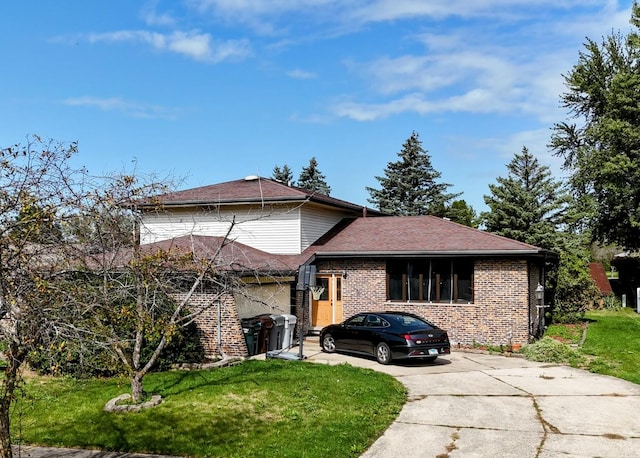 split level home with a front yard, concrete driveway, and brick siding