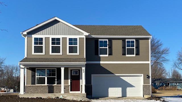 view of front of property with covered porch, driveway, brick siding, and a garage